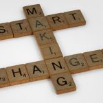 Top view of Scrabble tiles forming the phrase 'Start Making Changes' on a white background.